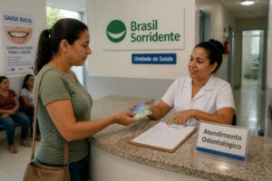 A Brazilian woman hands documents to a clinic receptionist while registering for Brasil Sorridente dental care at a public health unit.