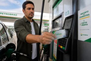 Brazilian man pays for fuel at a Petrobras gas station using a Petrobras Premmia credit card to get fuel discount and points.